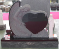 Upright memorial with an angel embracing a heart
